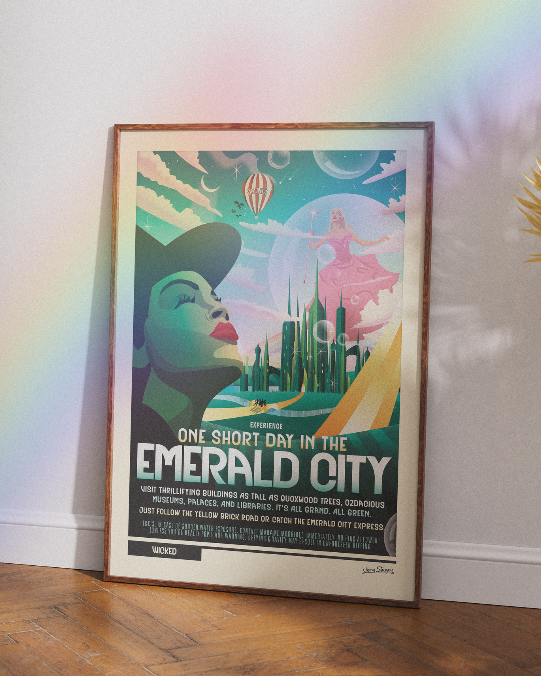 One Short Day Wicked poster in a wooden frame leaning against a white wall on a parquet floor