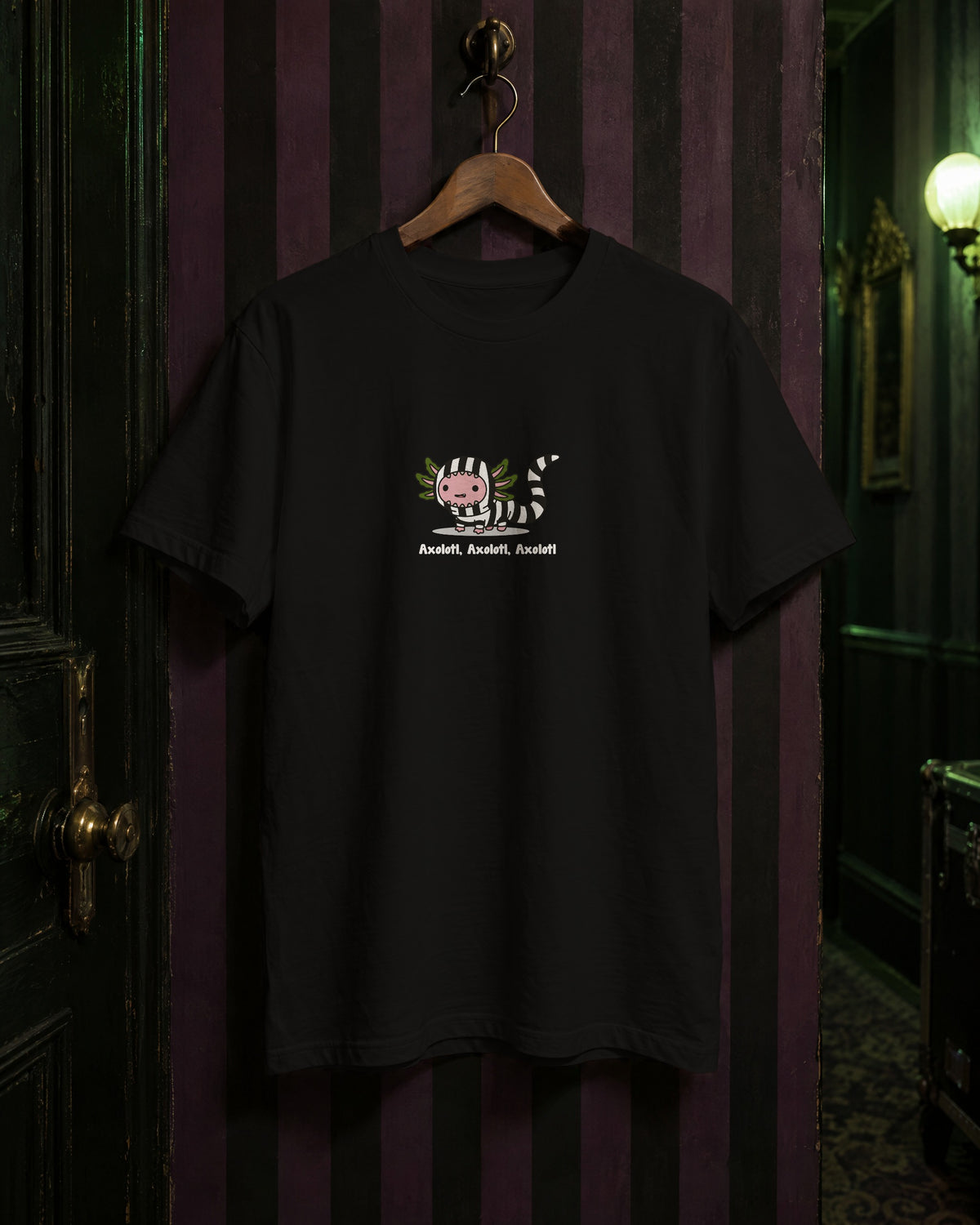 Axolotl Beetlejuice t-shirt in Black on a hanger against black-and-purple striped wallpaper