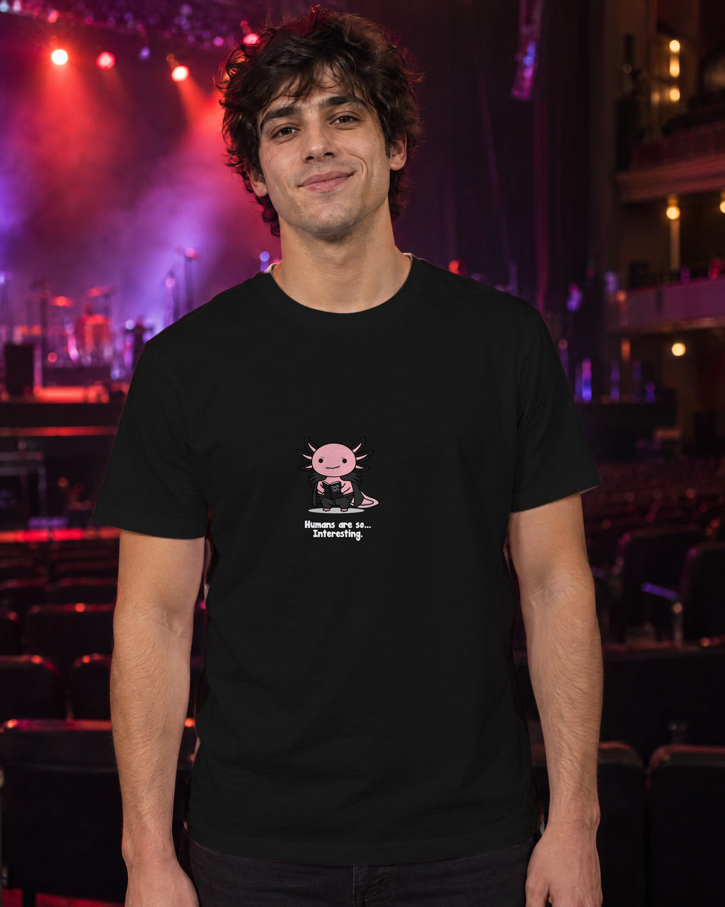 Humans Are So Interesting t-shirt in Black, worn in a theatre under red and violet stage light