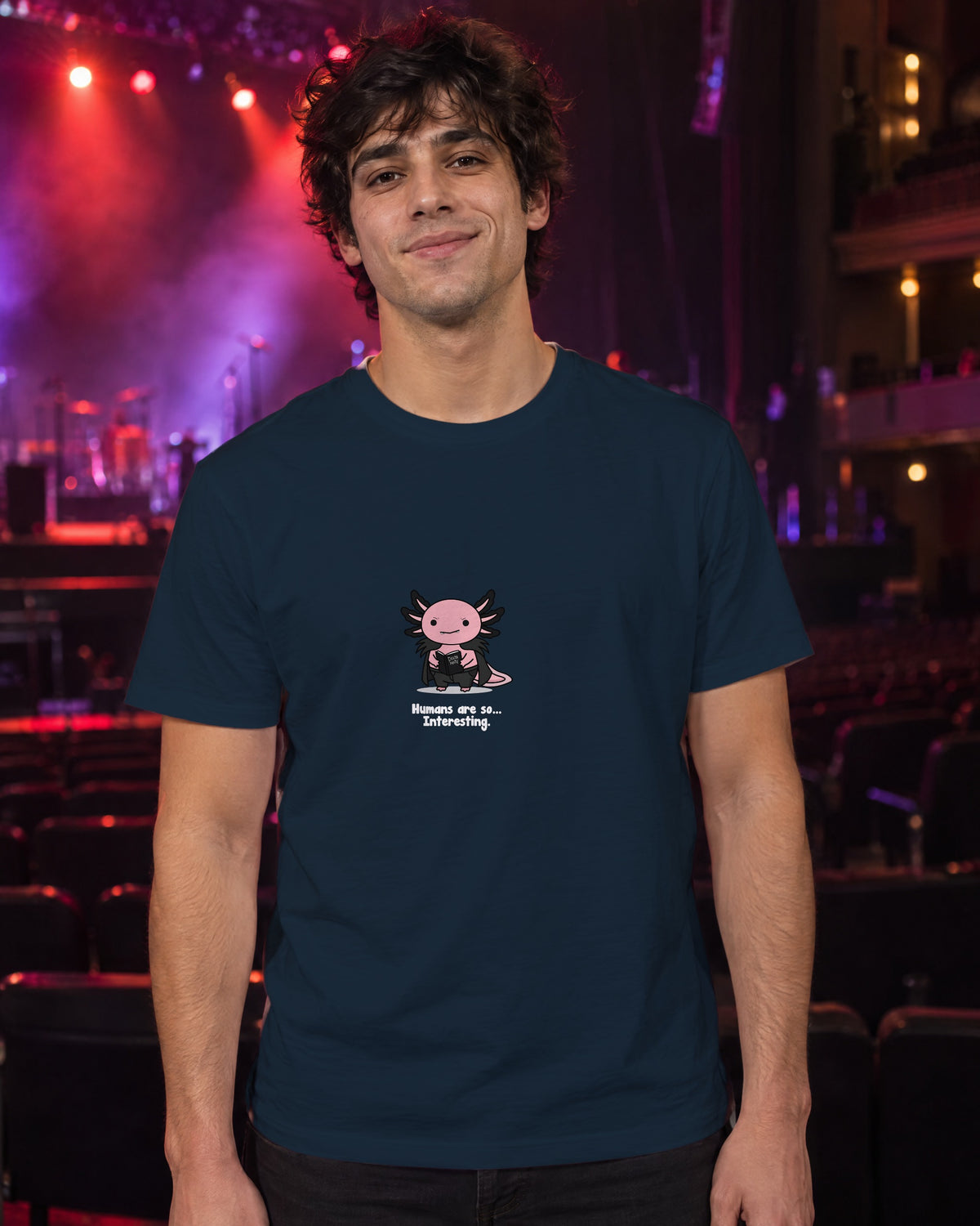 Humans Are So Interesting t-shirt in French Navy, worn in a theatre under red and violet stage light